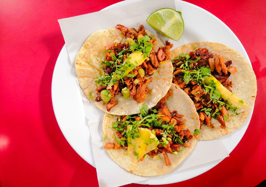 Delicious tacos with savory meat, fresh toppings, and lime, showcasing authentic Mexican cuisine.