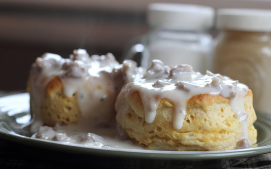 Golden biscuits covered in creamy sausage gravy, a classic Southern comfort food dish.
