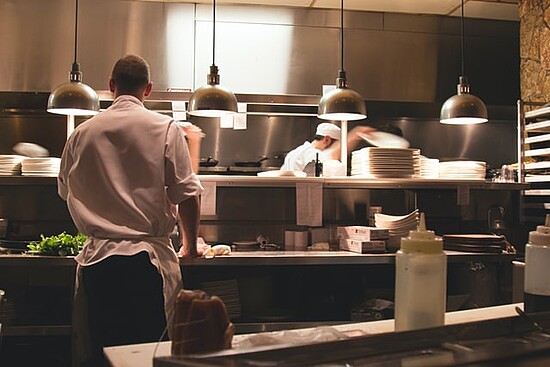 Chefs working in a busy restaurant kitchen, showcasing culinary preparation and teamwork.