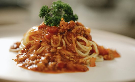 Delicious spaghetti in rich tomato sauce, garnished with parsley, perfect for pasta lovers.