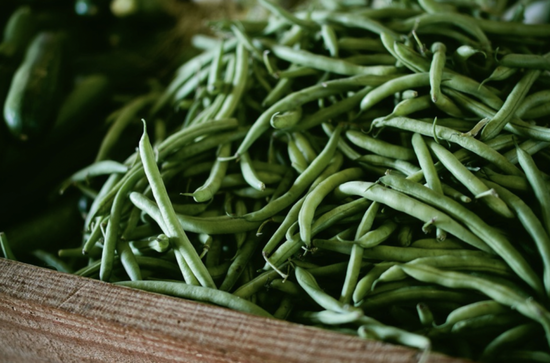 Fresh green beans in a rustic wooden container celebrating farm-to-table vitality and abundance.