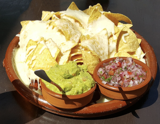 Delicious nachos topped with cheese, guacamole, and salsa, perfect for sharing at gatherings.
